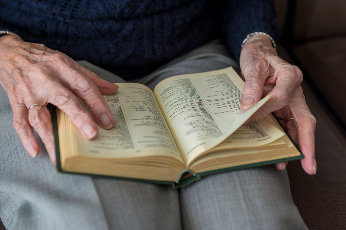 Anziano legge un libro (Foto di Sabine van Erp da Pixabay 