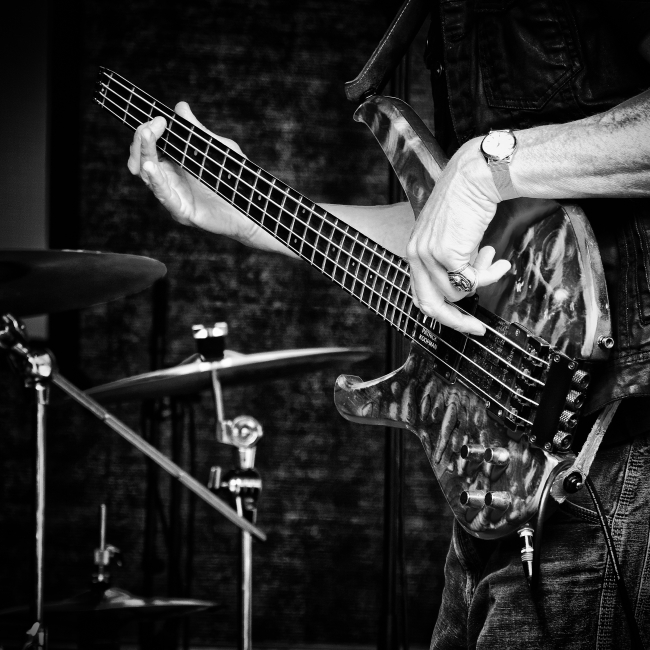 Un chitarrista suona una chitarra elettrica dal design elaborato in bianco e nero