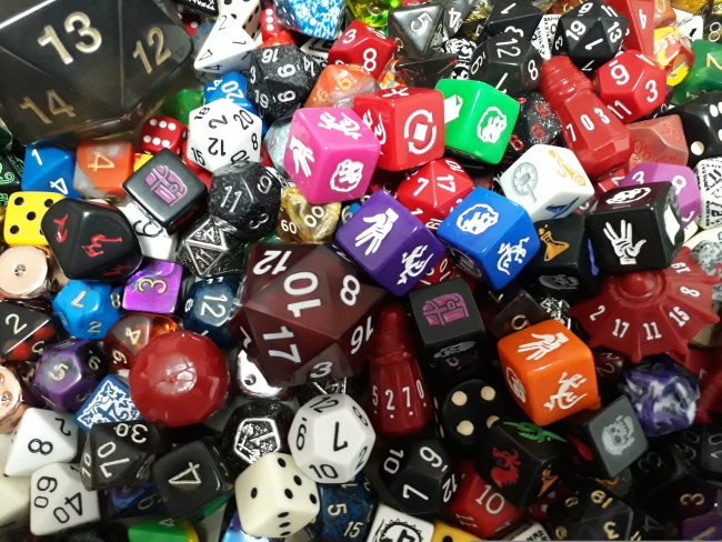 Una vivace composizione di dadi da gioco di diverse forme, colori e dimensioni.